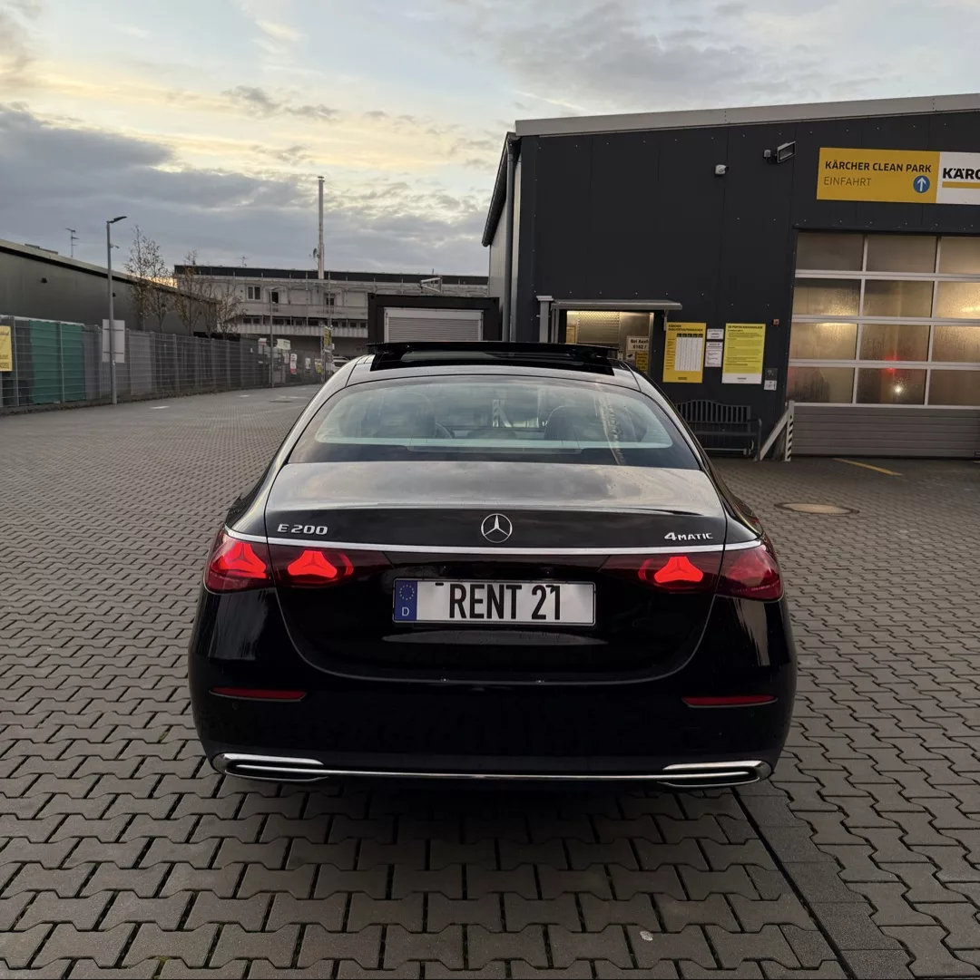 Mercedes-Benz E200 4MATIC in Schwarz von hinten mieten