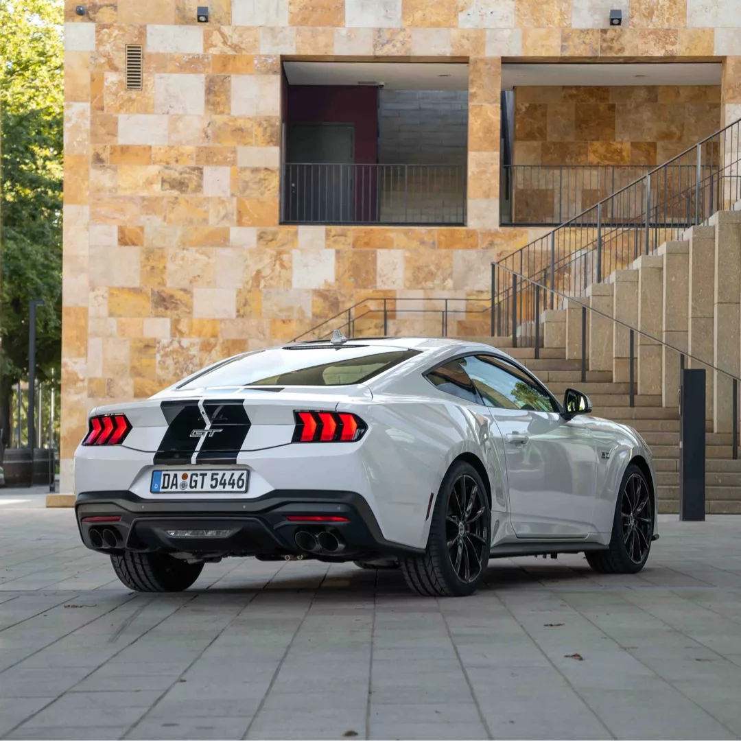 Ford Mustang GT 2024 in Weiß mit schwarzen Streifen von hinten mieten.