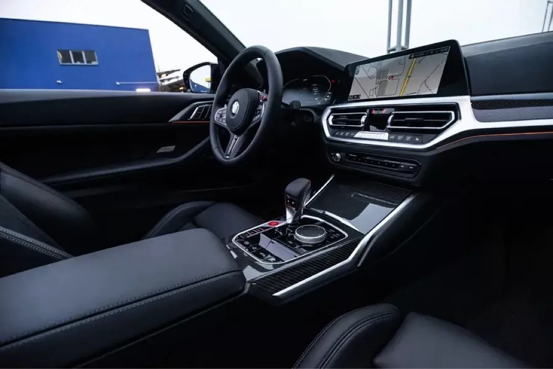 Innenraum eines BMW M4 Cabrio Competition mit modernem Cockpit und Navigationssystem.