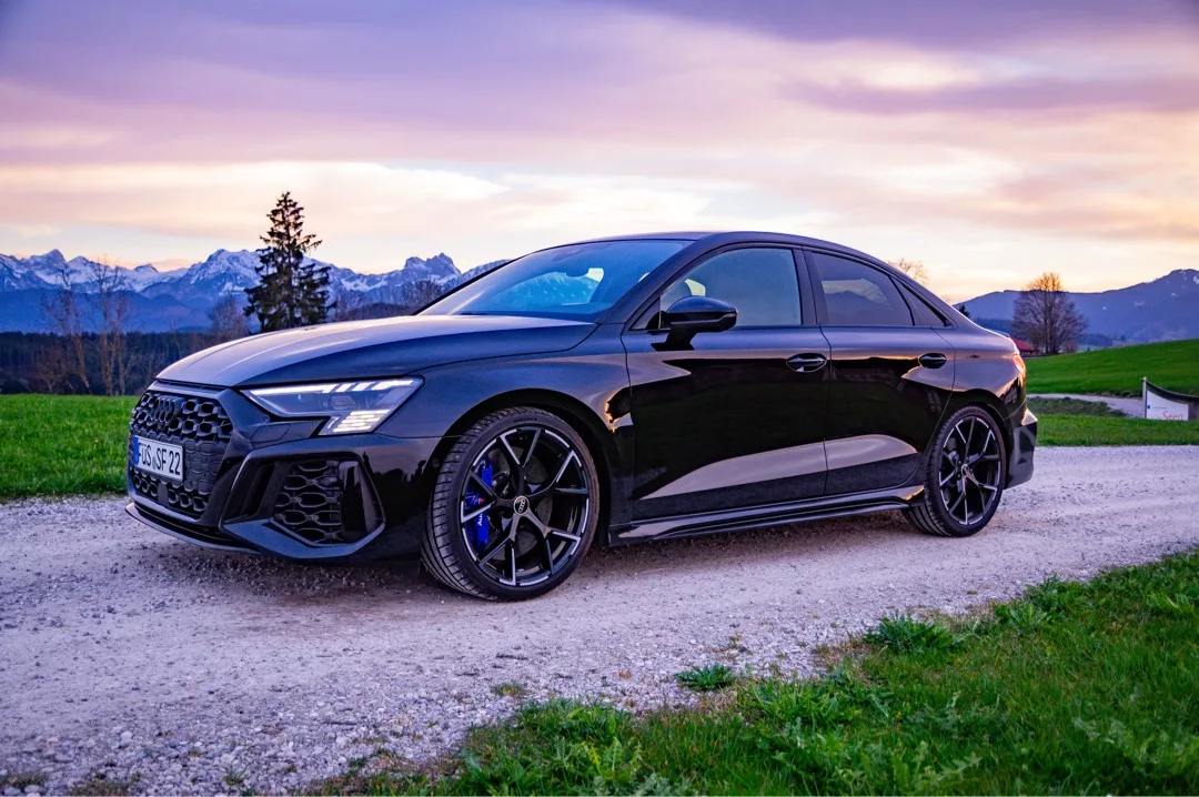 Audi RS3 Limousine in Schwarz vor Bergkulisse mieten.