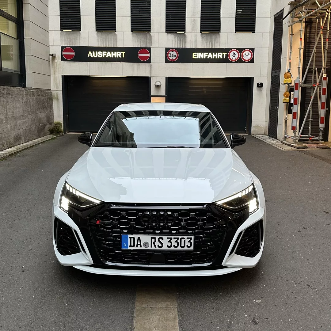 Audi RS3 Limousine in Weiß, Frontansicht, vor Garage mieten