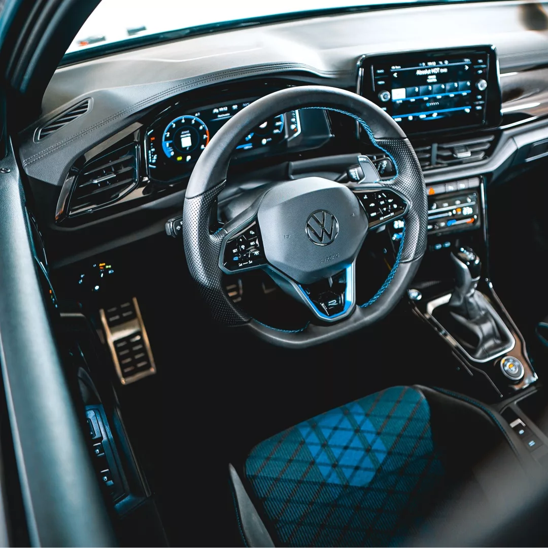 Innenraum eines VW T Roc R mit modernem Lenkrad und Cockpit.