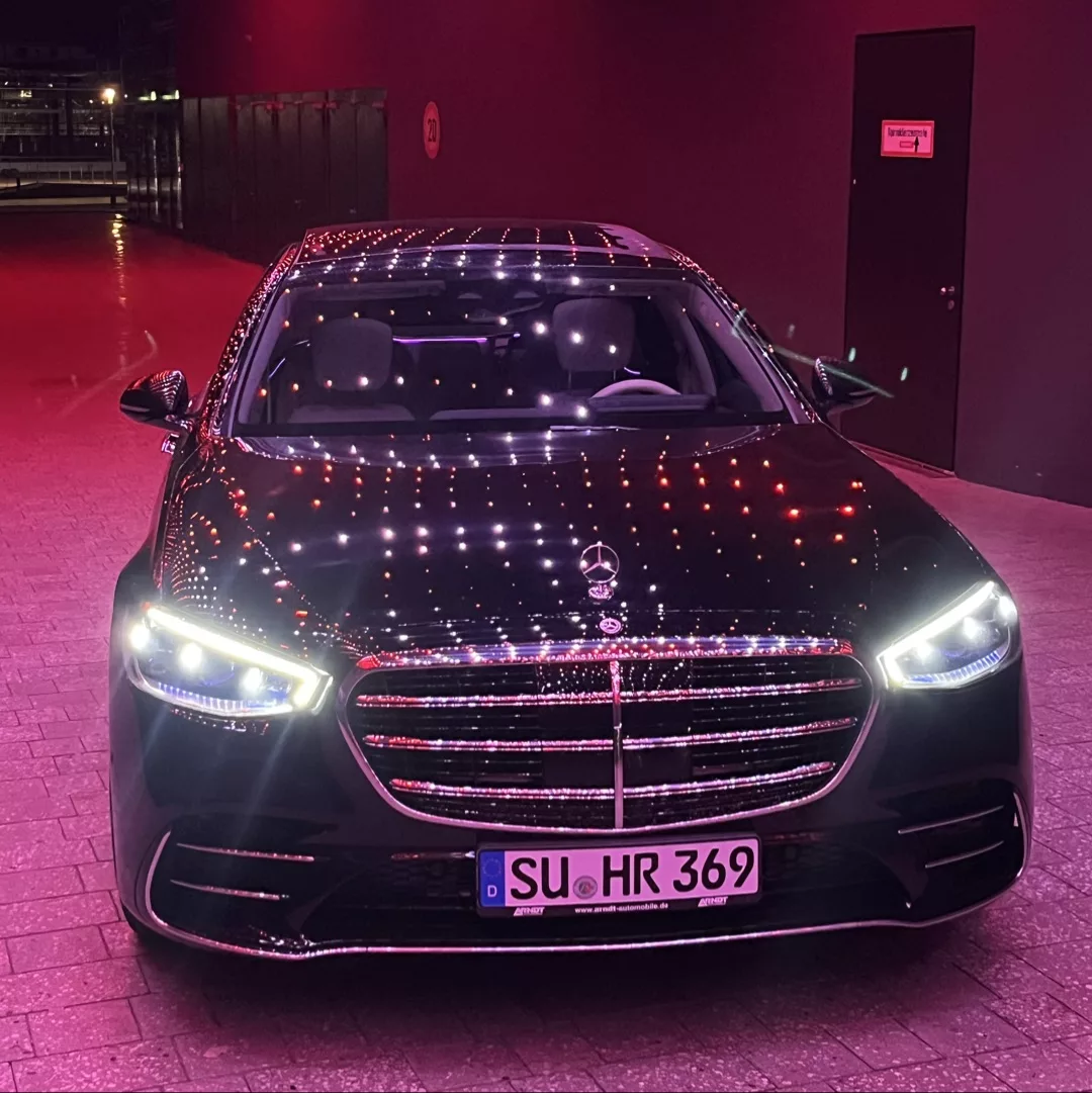 Mercedes Benz S-Klasse in Schwarz mit Frontansicht bei Nacht mieten.