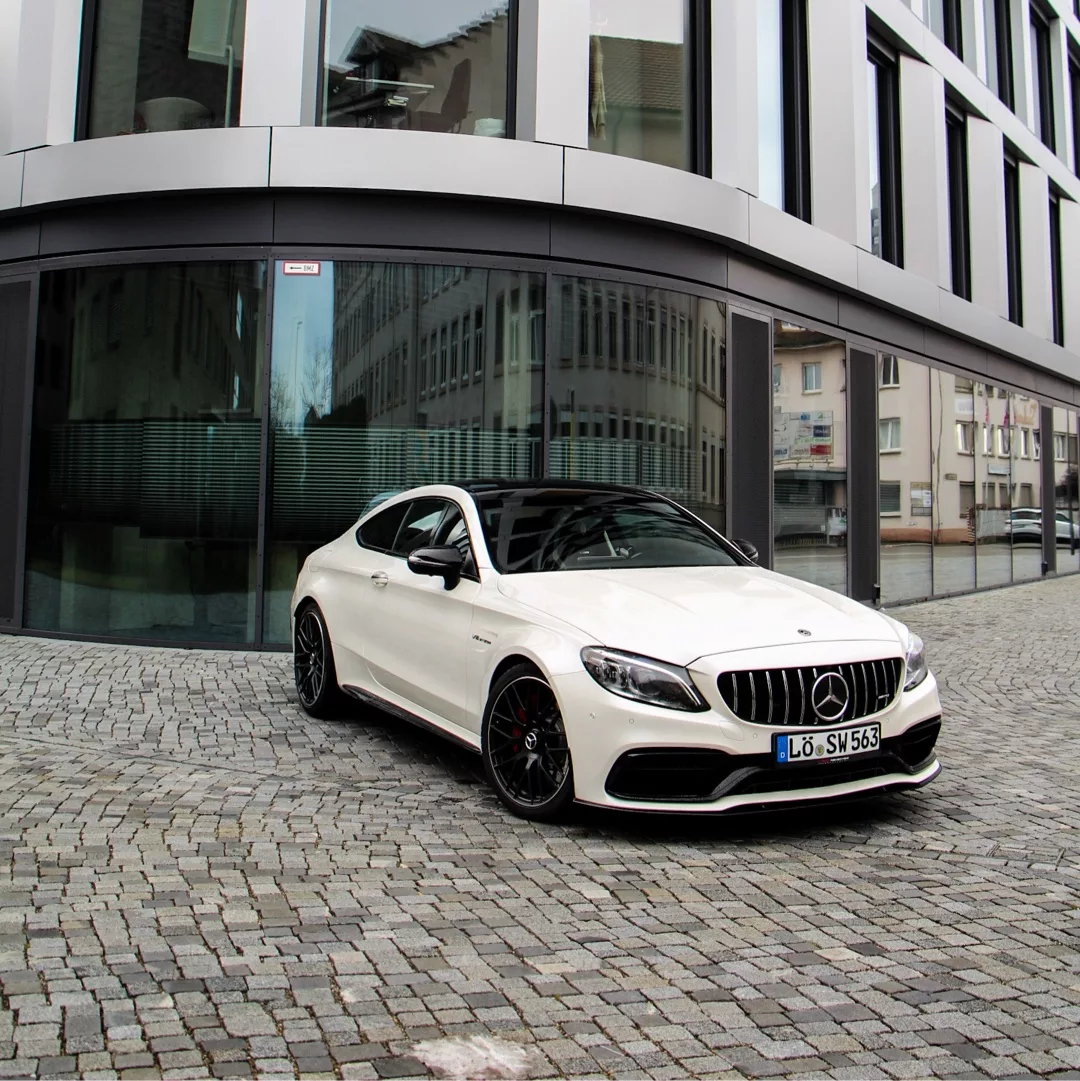 Mercedes-Benz C63s AMG Coupé in Weiß vor Gebäude mieten