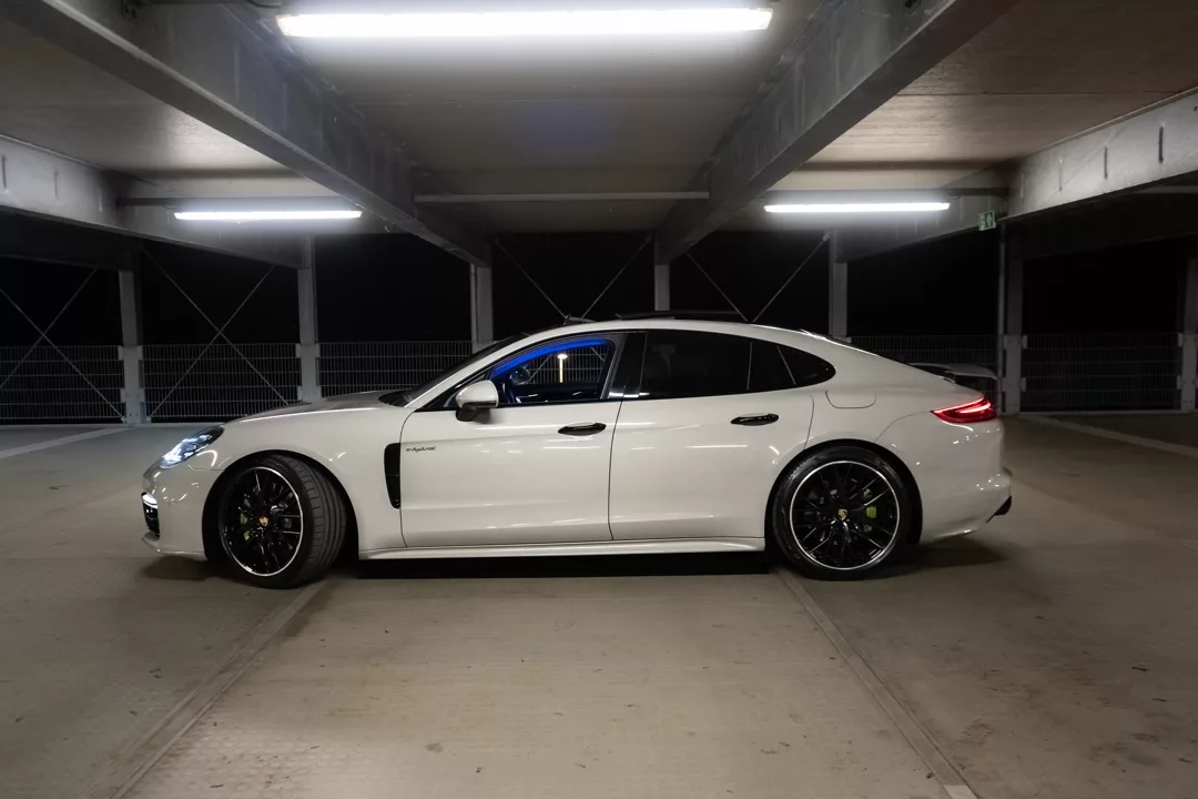 Porsche Panamera mit Sportabgasanlage in Weiß von der Seite mieten.