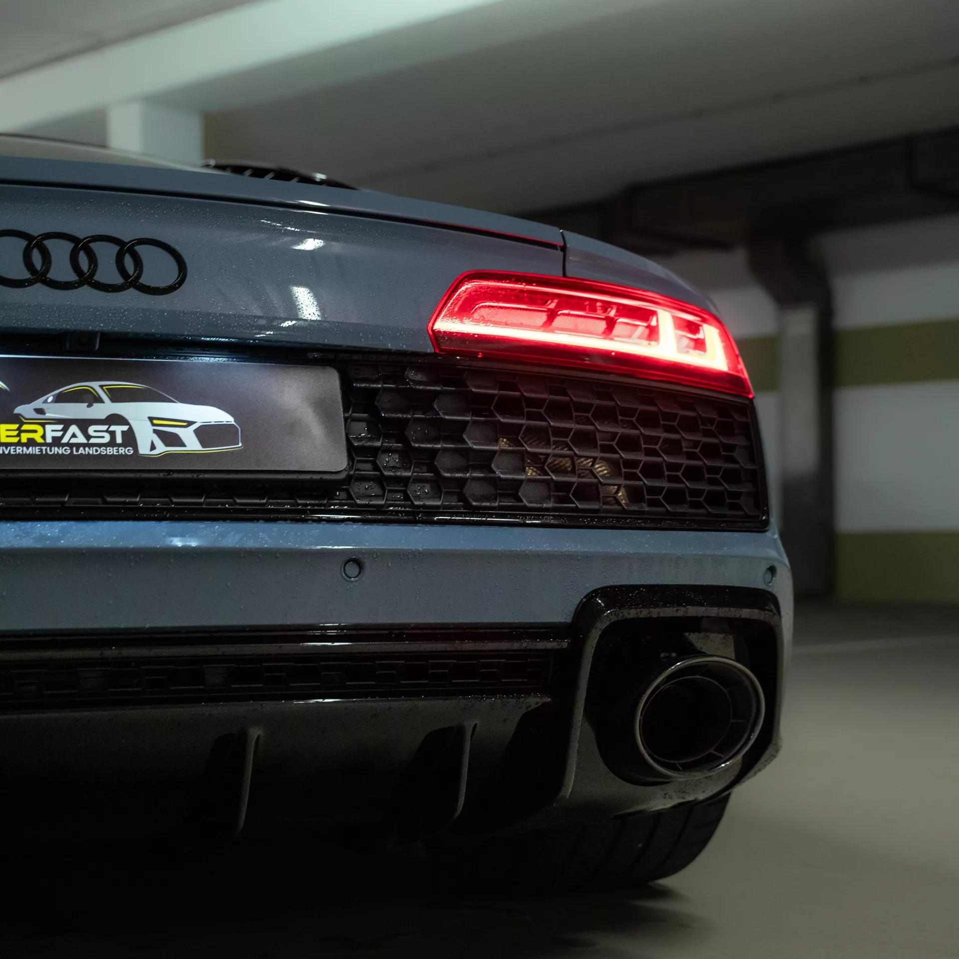Audi R8 V10 Performance Coupe in Grau mieten - Heckansicht im Parkhaus.