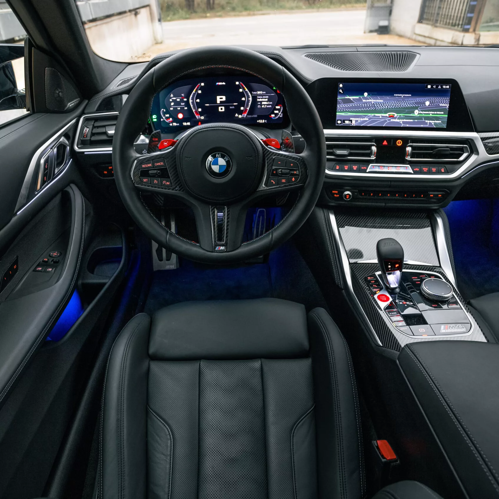 Innenraum eines BMW M4 Competition mit digitalem Cockpit und luxuriöser Ausstattung.