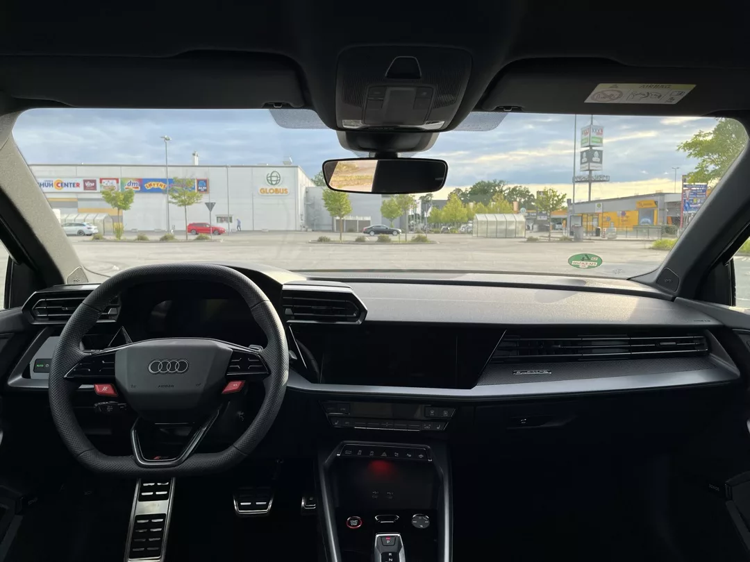 Innenansicht eines Audi RS3 mit Blick auf das Armaturenbrett und den Lenkradbereich.
