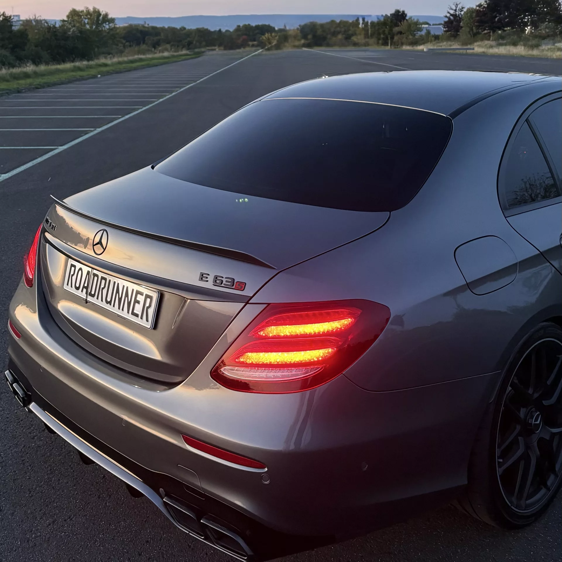 Mercedes AMG E63s Sportwagen in Grau von hinten mieten.