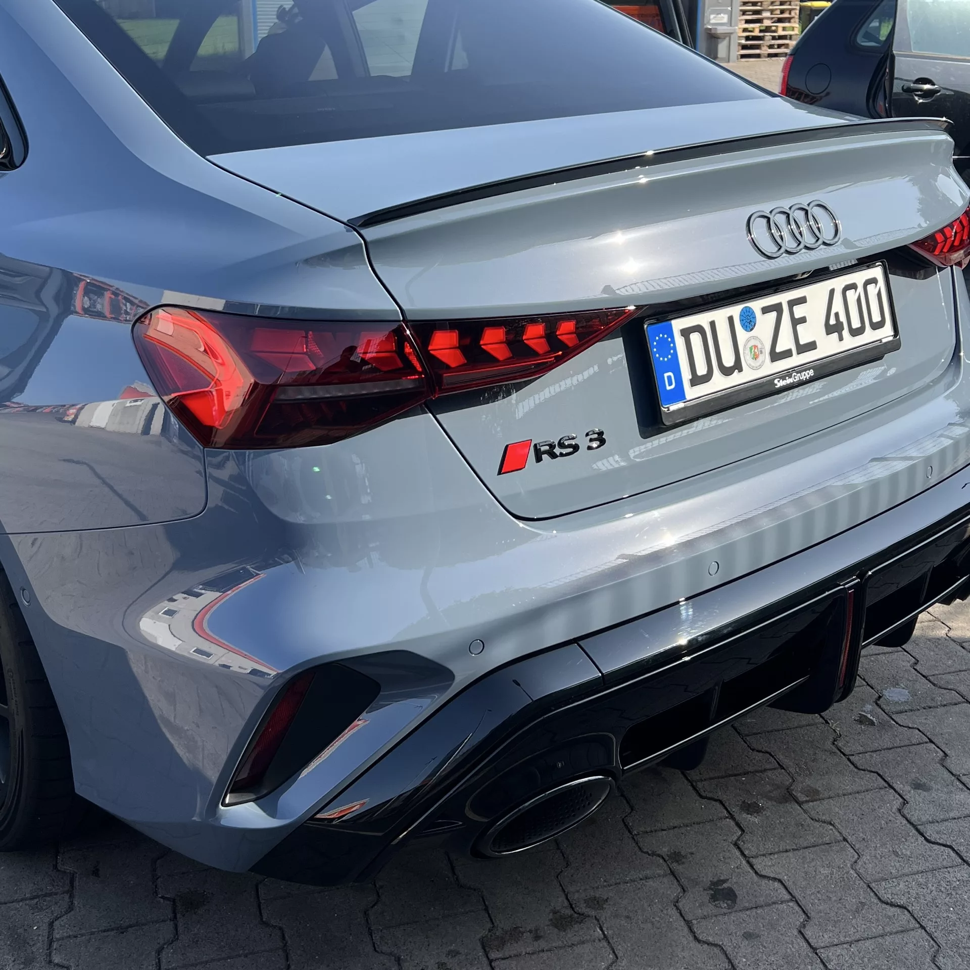 Audi RS3 Limousine Facelift in Grau, Heckansicht mieten