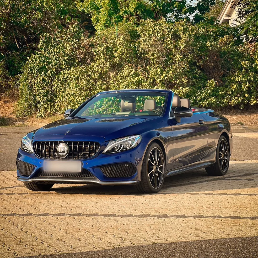 BRABUS 450 Cabrio in Blau mieten - Frontansicht bei Sonnenuntergang.