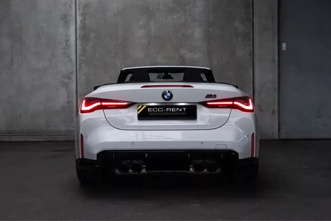 Weißes BMW M4 Cabrio Competition von hinten in einer grauen Garage.