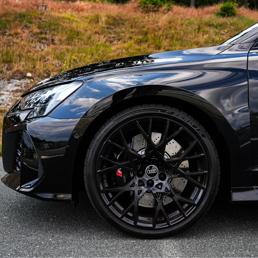 Audi RS3 Limousine Facelift in Schwarz, Fokussierung auf Vorderrad, mieten.