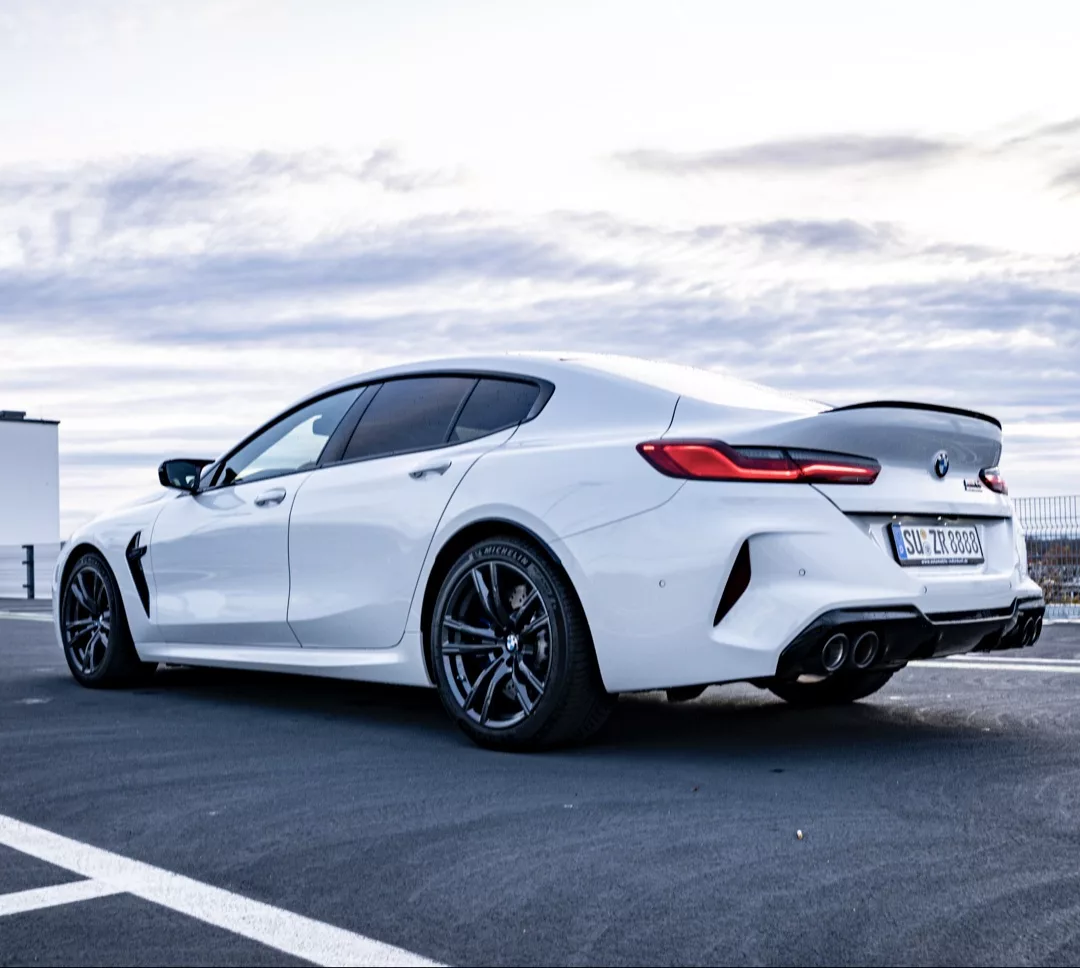BMW M8 CS Gran Coupe in Weiß von der Seite mieten.
