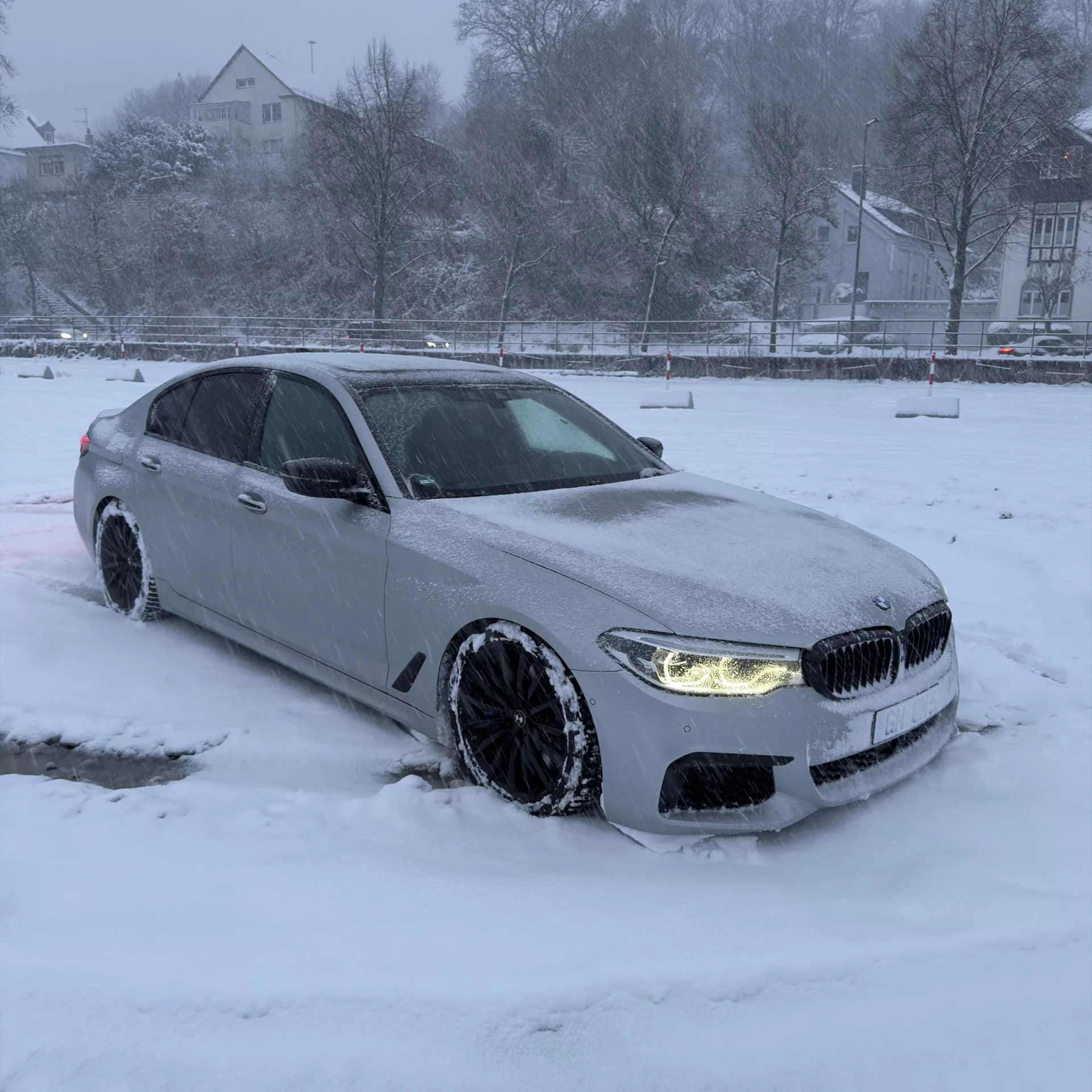 BMW m550i v8 in Weiß bei Schnee, Frontansicht mieten.