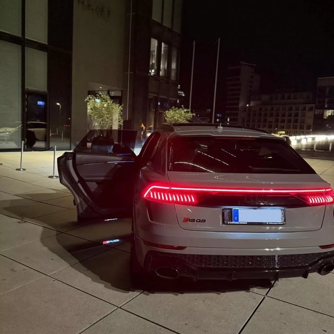 Audi RSQ8 in Grau bei Nacht von hinten mieten