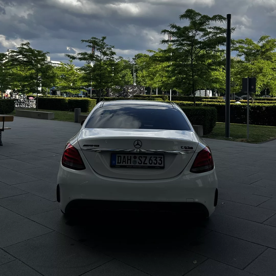 Mercedes C63s AMG Limousine in Weiß, Rückansicht, Stadtumgebung mieten.