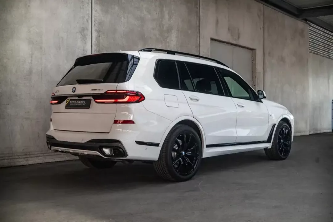 Weißer BMW X7 in einem überdachten Parkbereich.