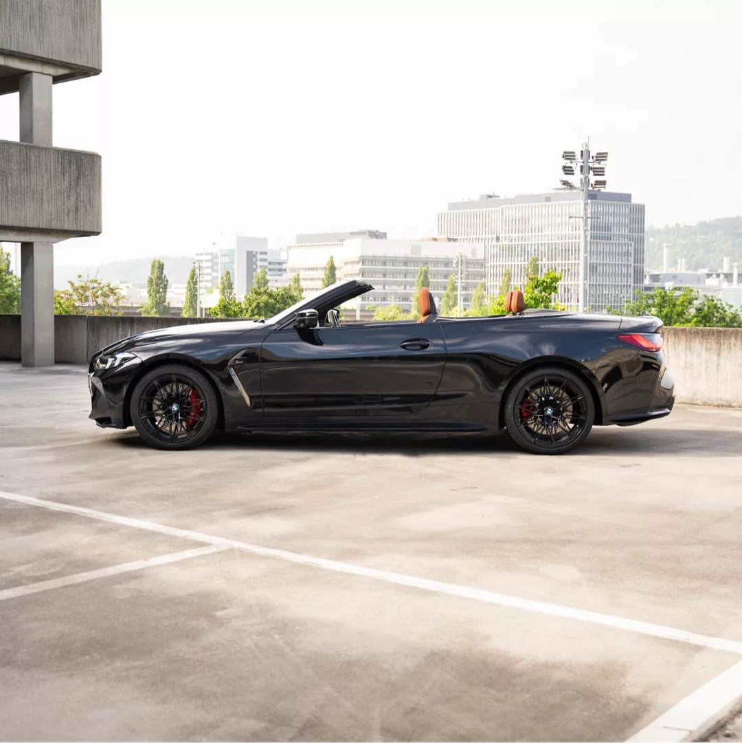 BMW M4 Competition Cabrio LCI in Schwarz von der Seite mieten.