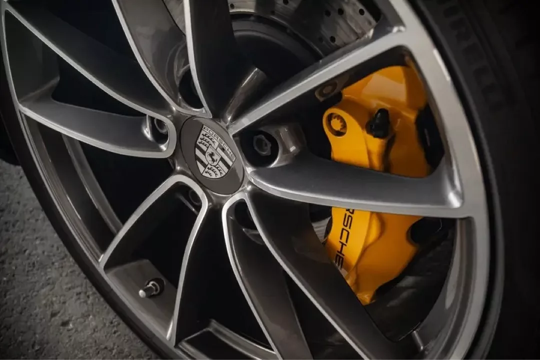 Nahaufnahme eines Porsche 911 Carrera S (992) Rads mit gelber Bremssattel.