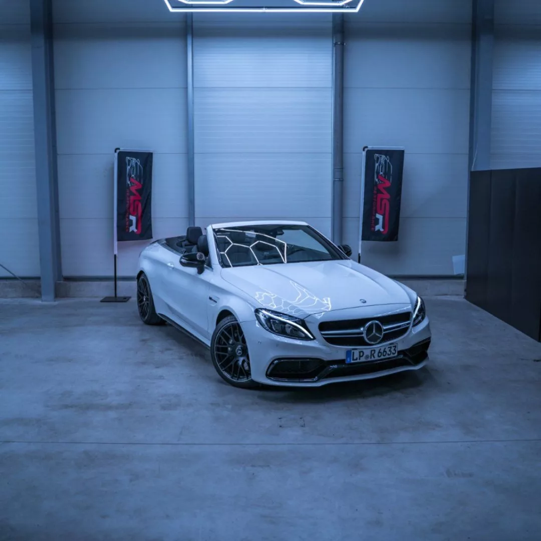 Mercedes C63 AMG Cabrio in Weiß mieten - Frontansicht in Garage