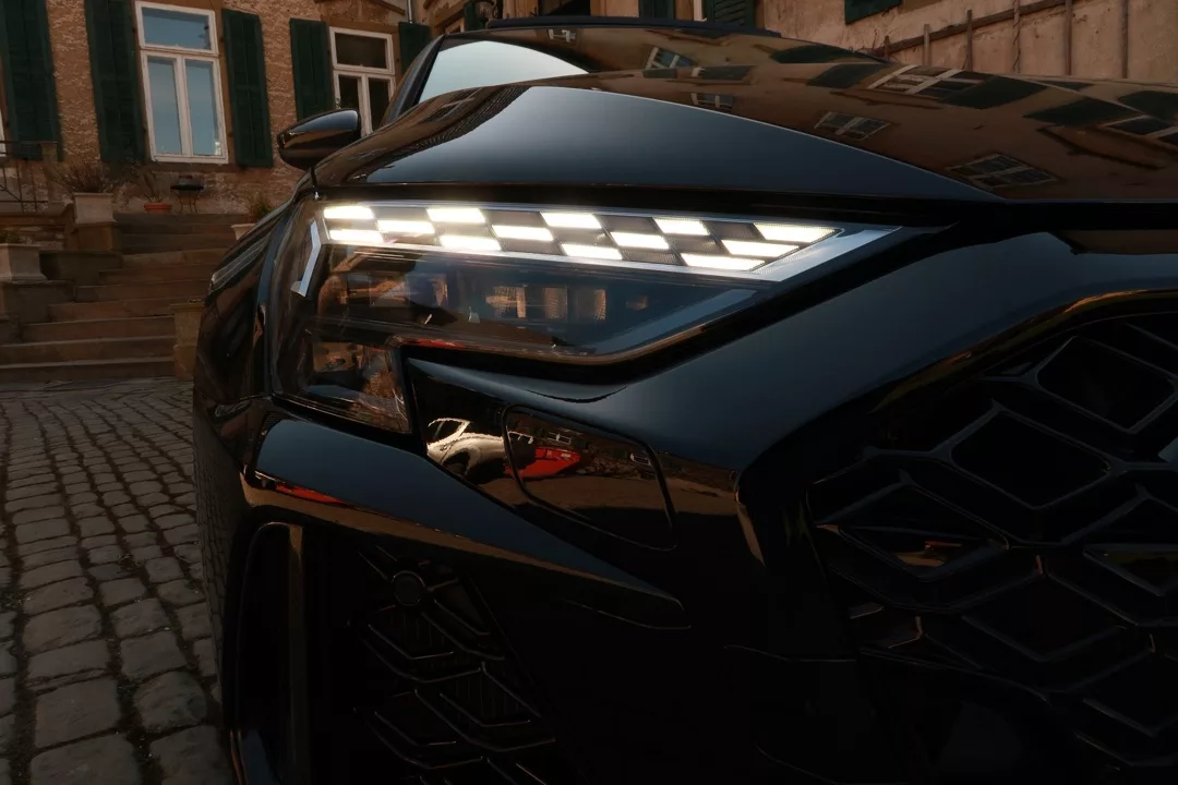 Audi RS3 Limousine in Schwarz, Nahaufnahme des Frontscheinwerfers mieten.