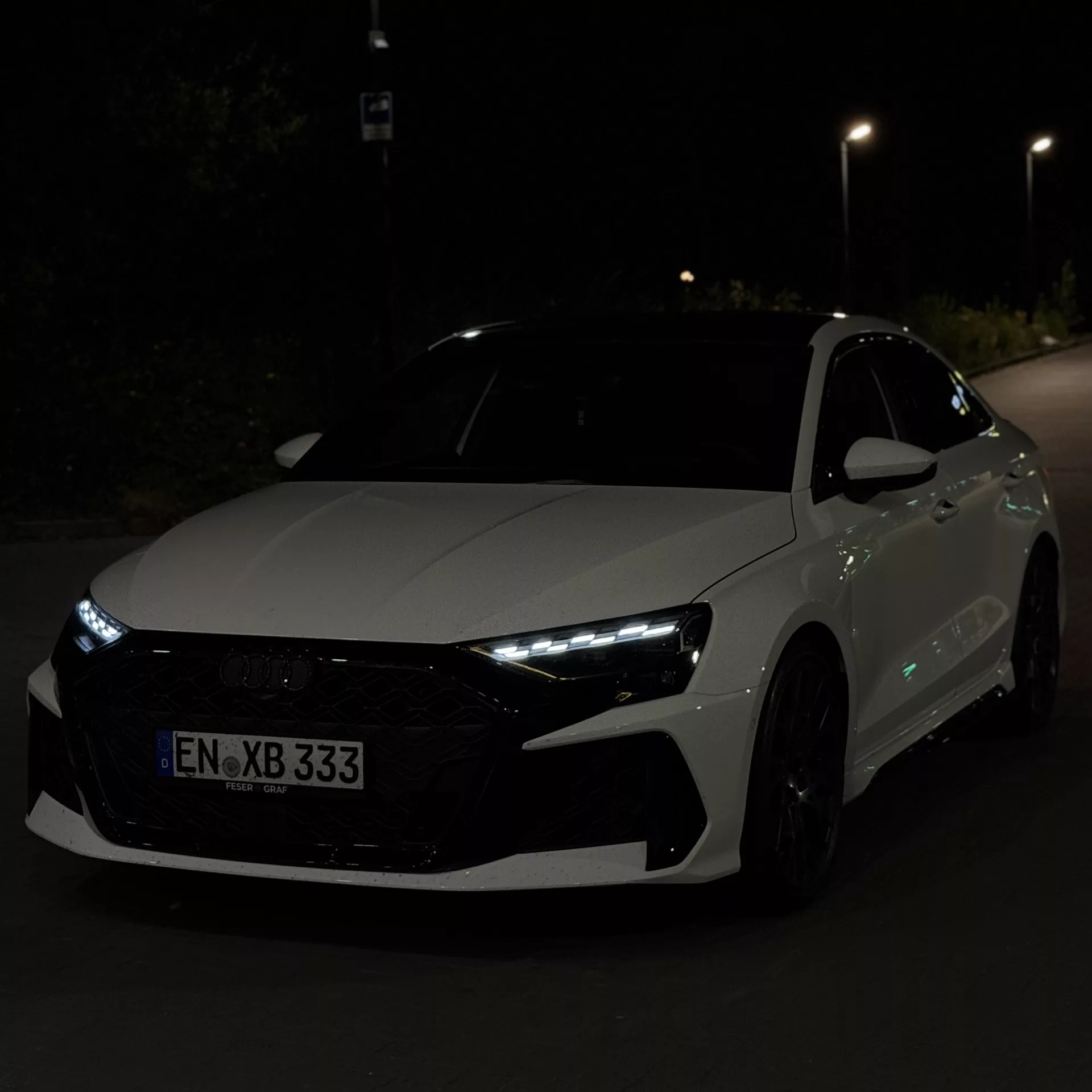 Audi RS3 Limousine 2025 in Rot, Frontansicht bei Nacht mieten.