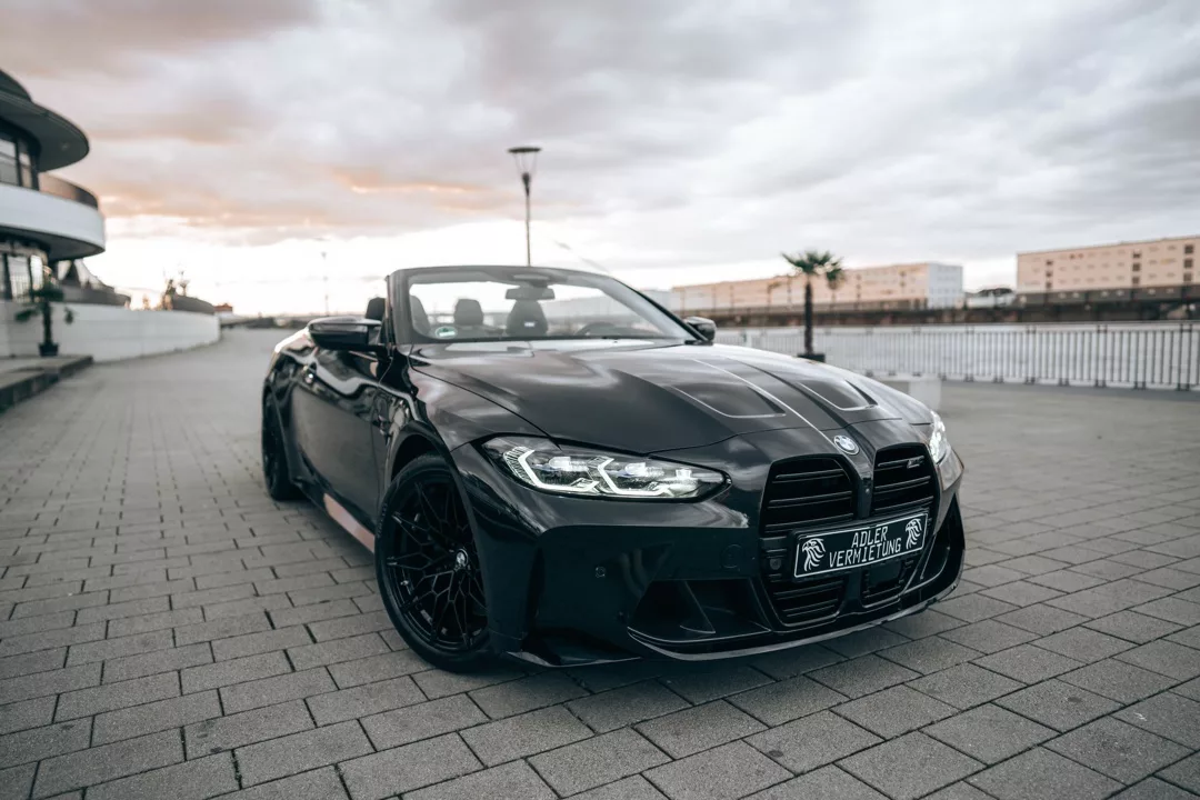 BMW M4 Competition Cabrio in Schwarz mieten - Frontansicht auf Straße