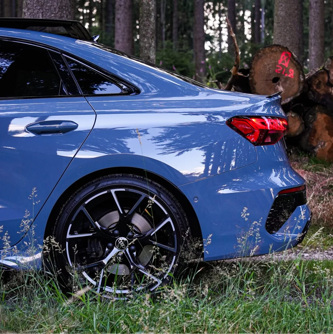 Audi RS3 in Blau, Heckansicht im Wald mieten.