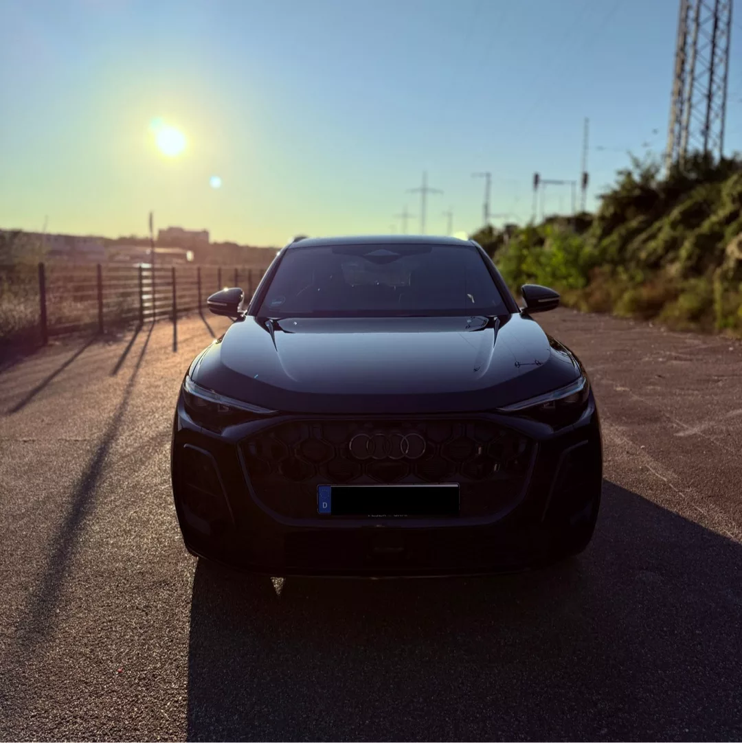 Audi Q5 S line TDI in Schwarz, Frontansicht bei Sonnenuntergang mieten.