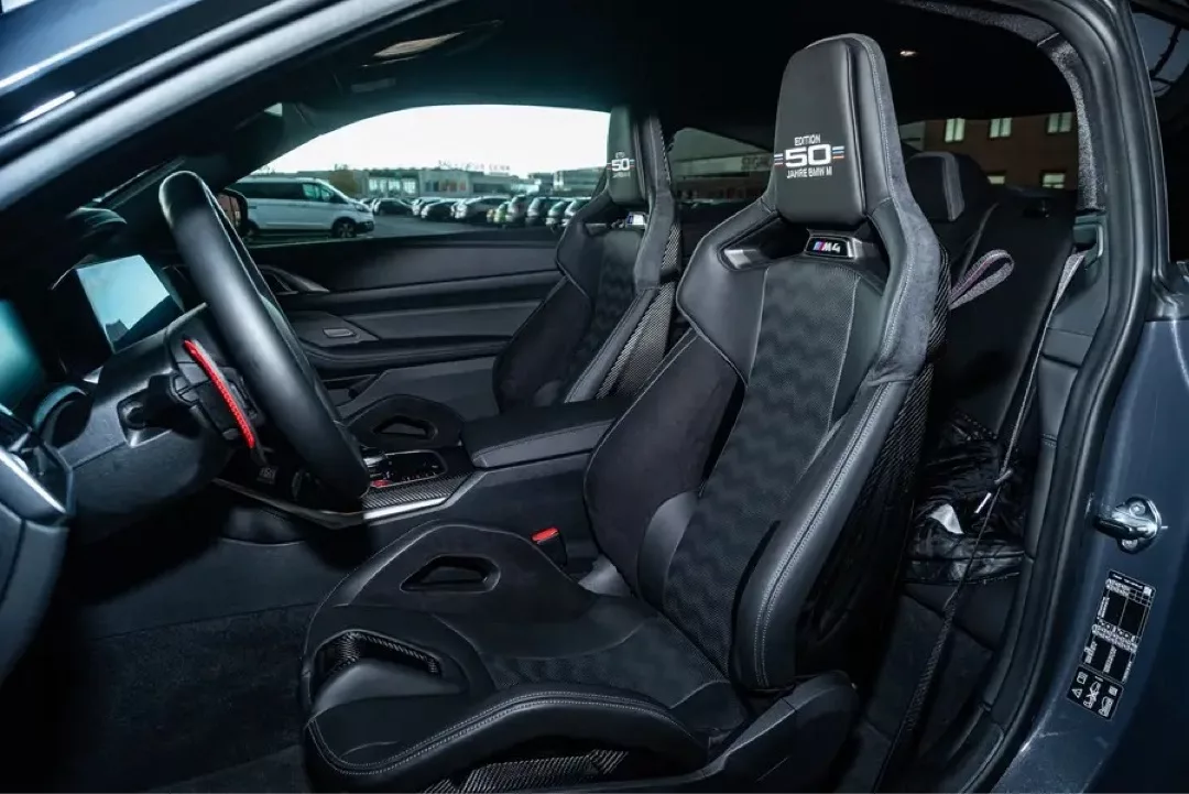 Innenraum eines BMW M4 Competition "50 Jahre" mit Sportsitzen und modernem Design.