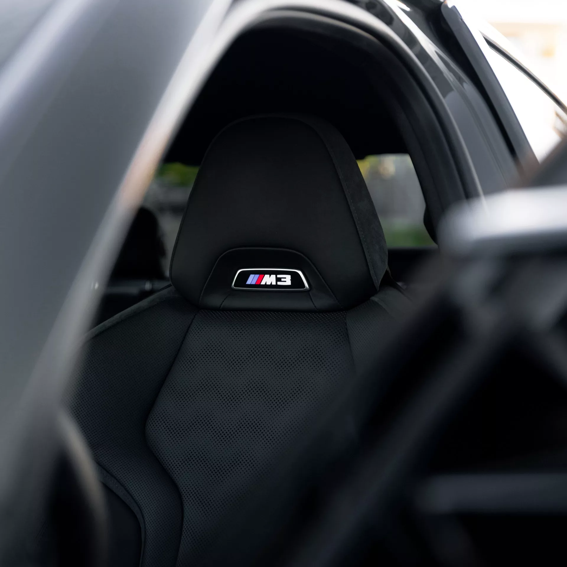 BMW M3 Competition XDrive Innenraum mit M-Logo auf Sitz mieten.