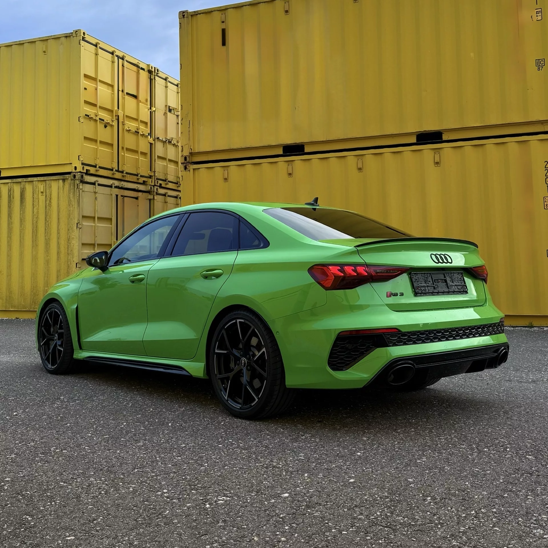 Audi RS3 in Grün von hinten vor Containern mieten