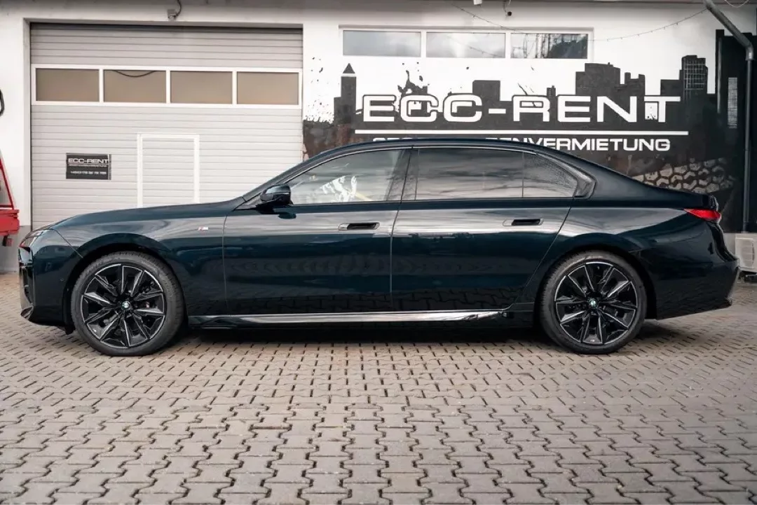 BMW 740d M xDrive in Seitenansicht vor einer Vermietungsstation.