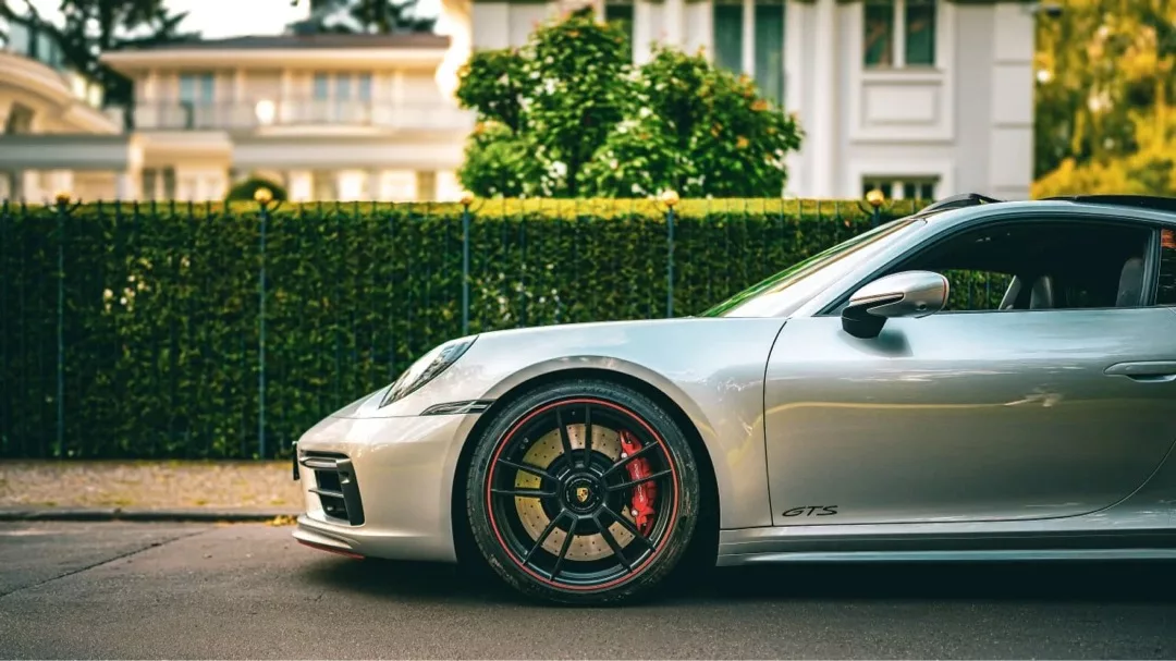 Porsche 911 Carrera 4 GTS in Silber mieten - Seitenansicht vor Villa