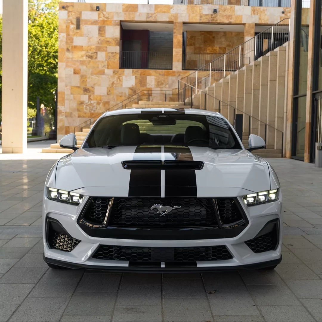 Ford Mustang GT (2024) in Weiß, Frontansicht mit Streifen, mieten.