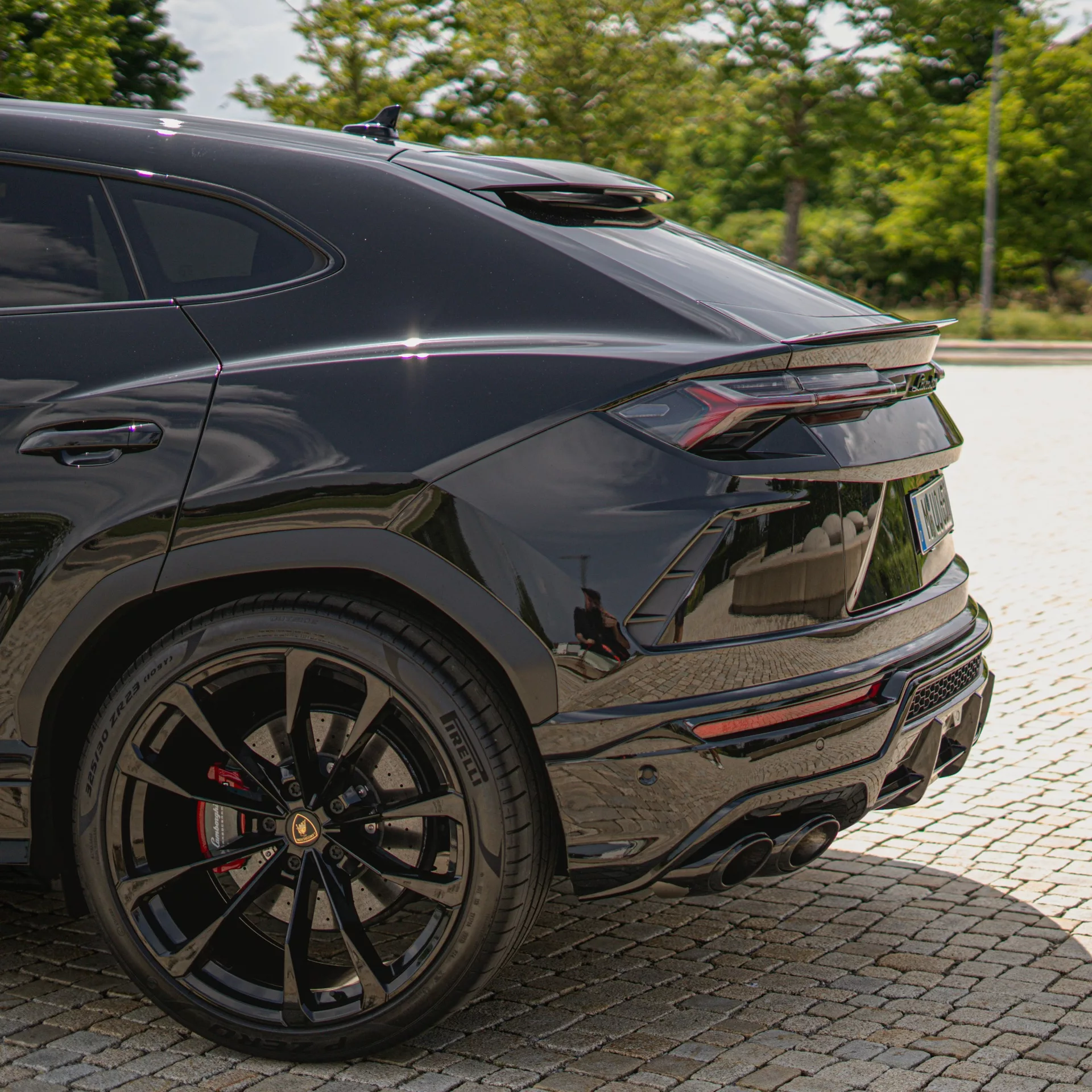 Lamborghini Urus in Schwarz von hinten mieten.