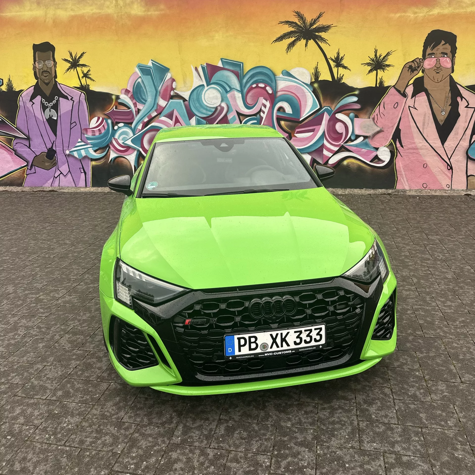 Audi RS3 Sportback in Grün vor Graffiti-Kunstwerk mieten