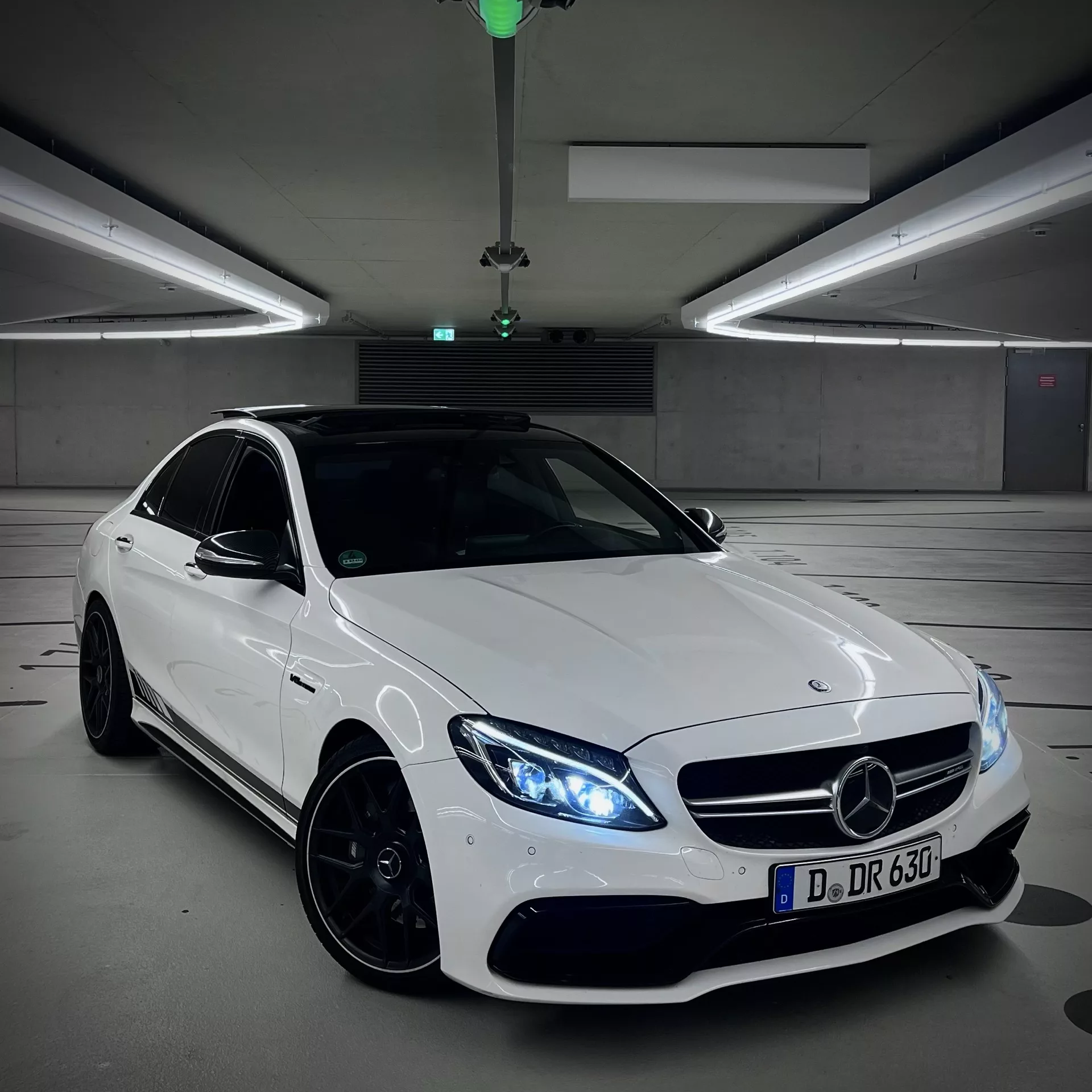 Mercedes C63 AMG in Weiß auf einem Parkplatz mieten